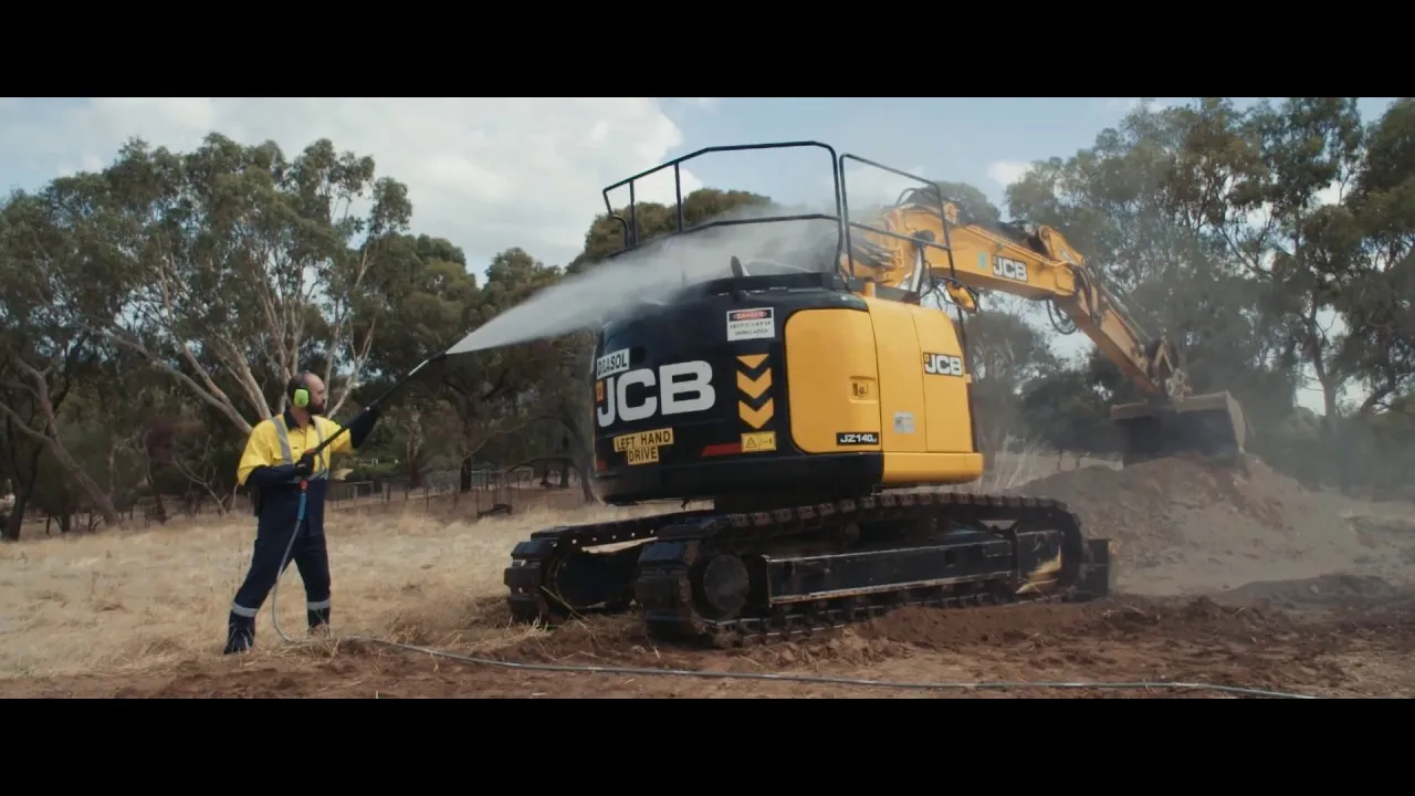 Worker with hearing protection cleaning a tractor.